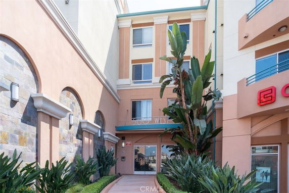 Front view of a multi-story building with modern design elements and landscaped entrance.