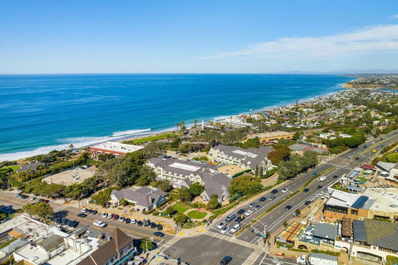 Panoramic view of a coastal town with buildings and roads adjacent to the ocean.