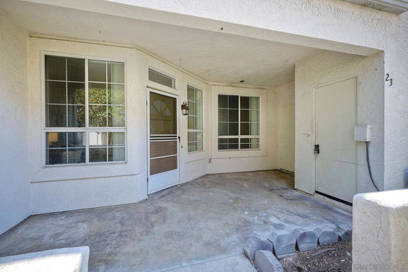 Front view of a house with a covered entryway and large windows.