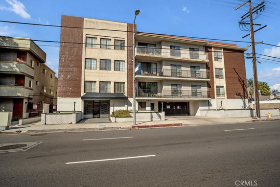 Front view of a multi-story apartment building with brick and concrete facade.