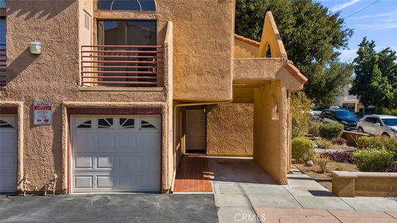 Front view of a two-story house with a garage and balcony.