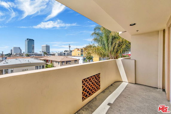 View from a balcony overlooking urban buildings and skyline.