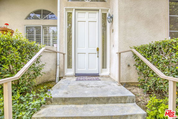 Front entrance of a house with a white door and porch steps.