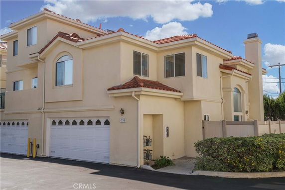 Front view of a multi-story house with a double garage and tiled roof.