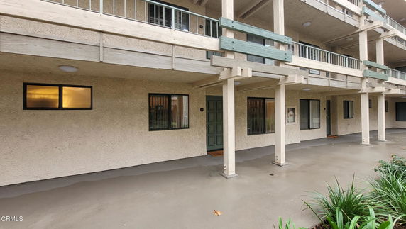 Front view of a two-story building with balconies and multiple windows.