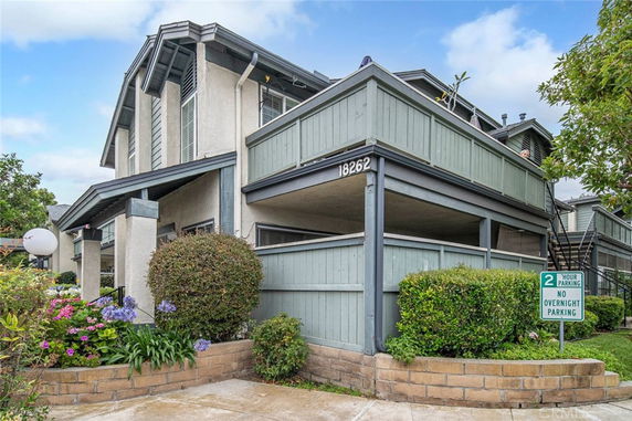 Front view of a two-story residential building with wooden fencing.