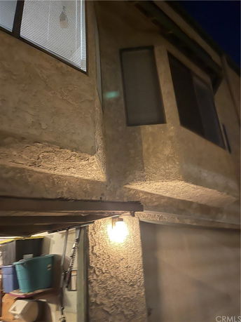 Exterior view of a building with textured walls and windows at night.