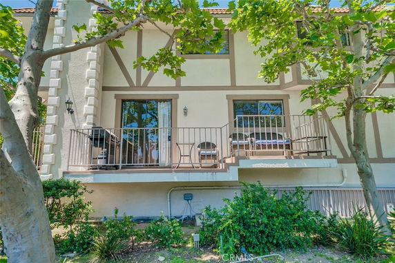 Front view of a multi-story house with balconies and large windows.