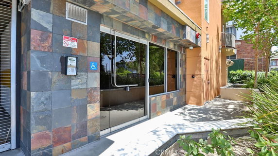Front view of a building with a glass entrance and slate tile exterior.