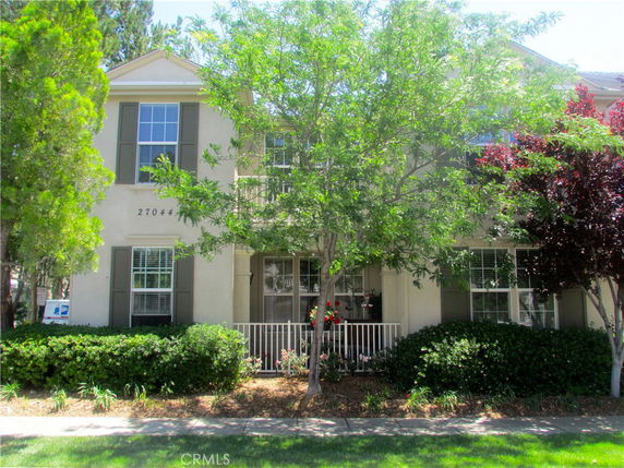 Front view of a two-story house with multiple windows and a small porch.