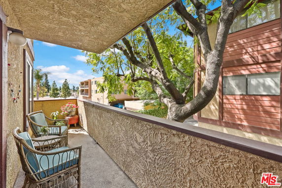 Balcony view of surrounding residential buildings and trees.