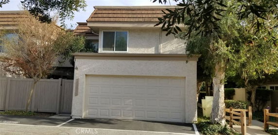 Front view of a two-story house with a double garage and sloped roof.