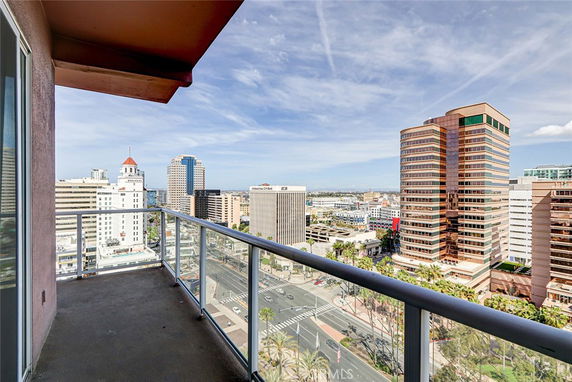 View from a high-rise balcony overlooking city buildings and streets.