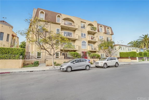 Front view of a four-story apartment building with balconies.