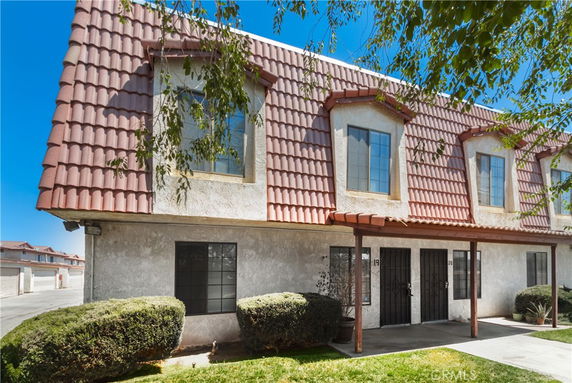 Front view of a two-story building with a tiled roof and multiple windows.
