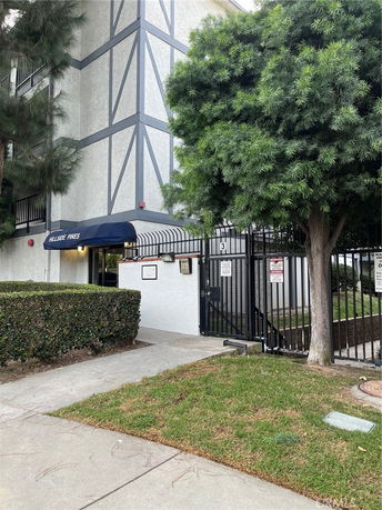 Front view of a multi-story building with geometric facade patterns and a gated entrance.