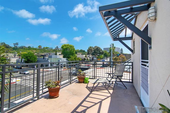 View from a balcony overlooking an urban area with roads and buildings.