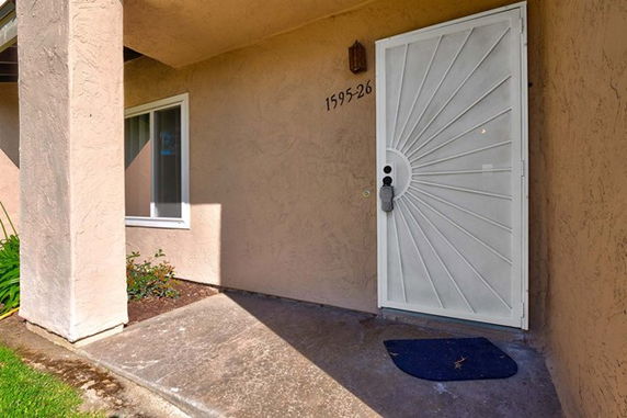View of a house entrance with a decorative security door and adjacent window.