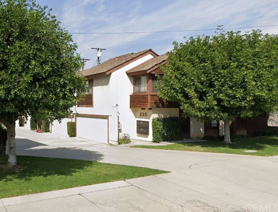 Front view of a two-story house with a garage and balcony.