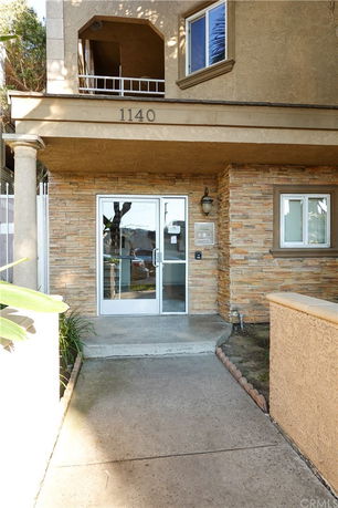 Entrance of a building with a glass door and stone facade.
