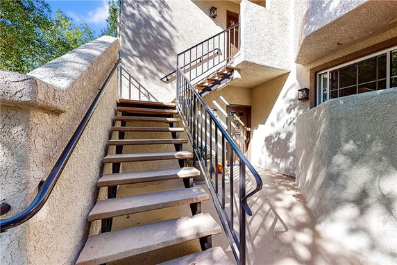Exterior view of a building entrance with a staircase leading to a doorway.