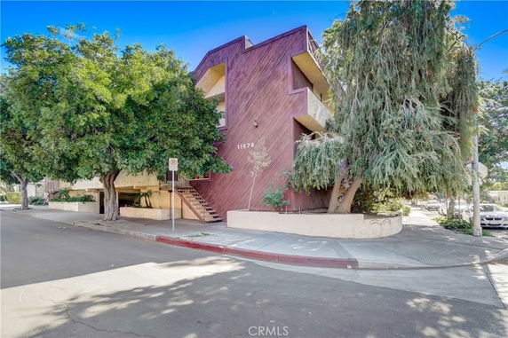 Front view of a multi-story apartment building with a unique architectural design and exterior staircase.
