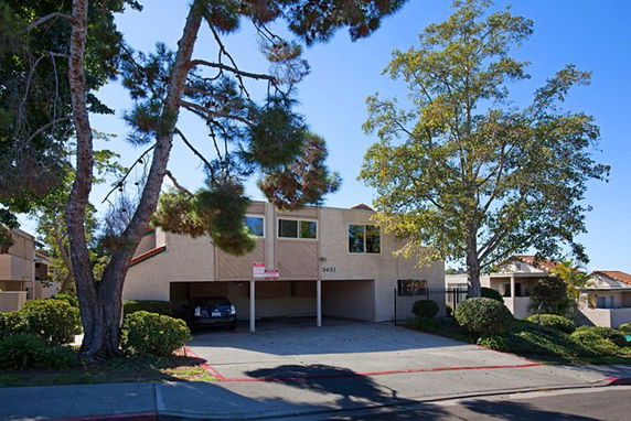 Front view of a two-story house with a carport and flat roof.