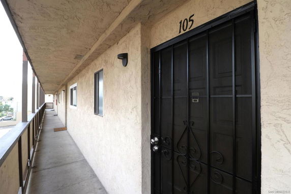 Corridor view with apartment doors and windows on one side.