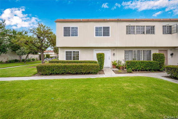 Front view of a two-story townhouse with a white exterior and multiple windows.