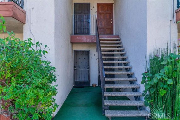 Entryway to a building with stairs leading to a second-floor door.