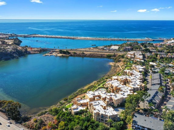 Aerial panoramic view of a coastal area with residential buildings near water bodies.