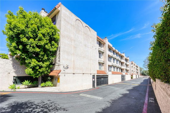 Front view of a multi-story apartment building with balconies.