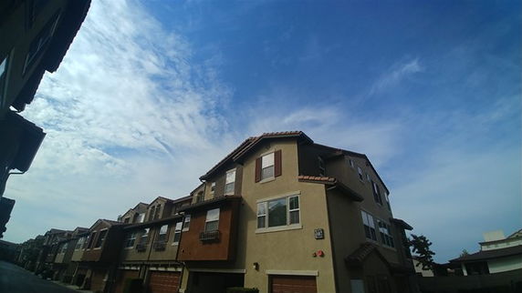 Front view of multi-story townhouse buildings with garages.