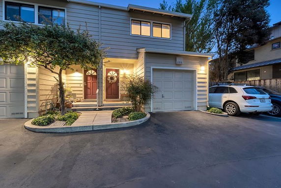 Front view of a two-story house with an attached garage and illuminated entrance.