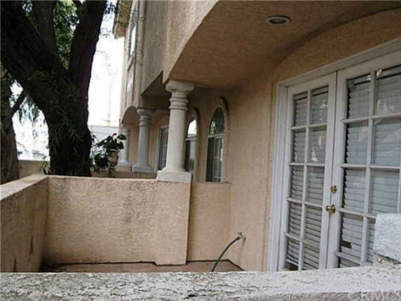 Exterior view of a building with columns and French doors.