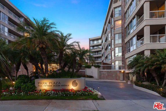 Front view of a multi-story building with balconies and landscaping.