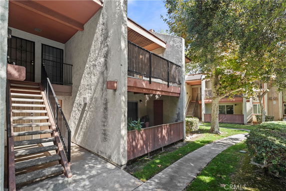 View of an apartment building with exterior staircases and balconies.