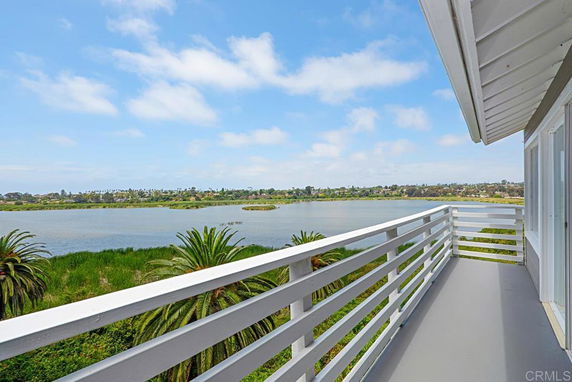 Balcony view overlooking water and greenery.