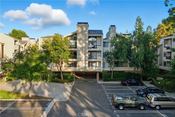 Front view of a multi-story apartment building with parking space in front.