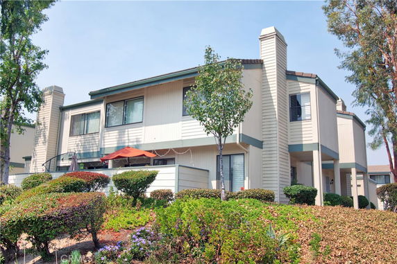 Front view of a two-story residential building with multiple windows and chimneys.