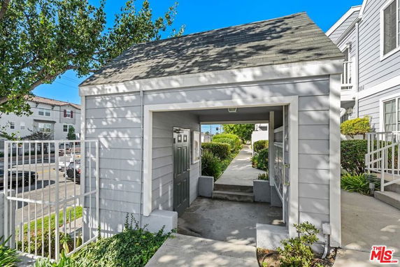 Front view of a small outdoor structure with a covered walkway.