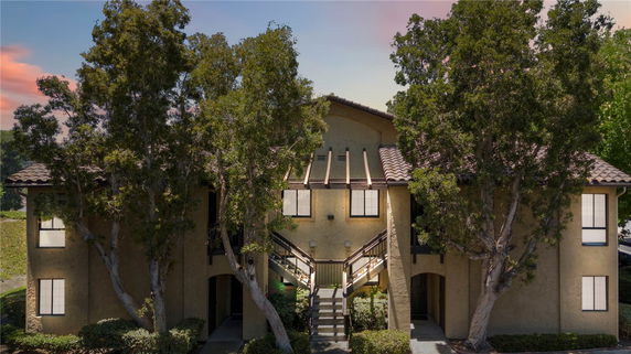 Front view of a two-story building with a central staircase and large windows.