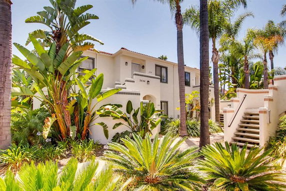 Front view of a two-story building with tropical landscaping.