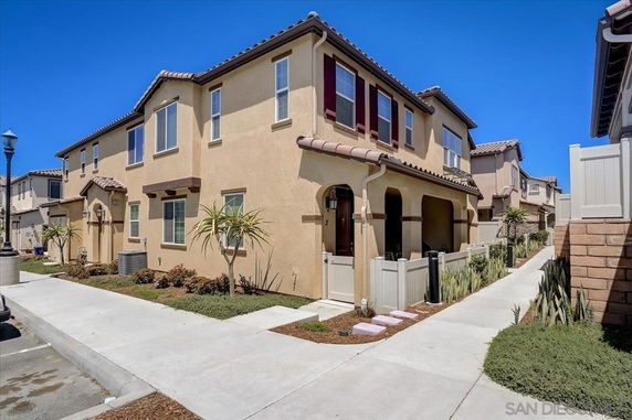 Front view of a two-story house with a tiled roof and arched entryway.