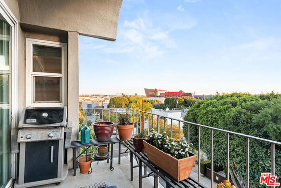 Balcony view overlooking surrounding buildings and greenery.