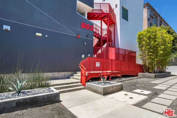 Front view of a modern building with red metal staircase and architectural details.