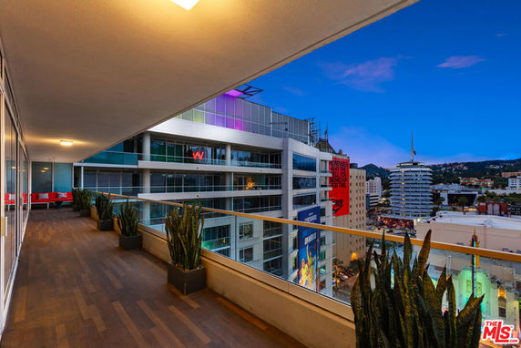 Building with balcony view overlooking cityscape at dusk.