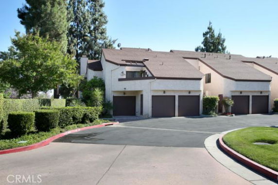 Front view of a multi-story townhouse complex with attached garages.