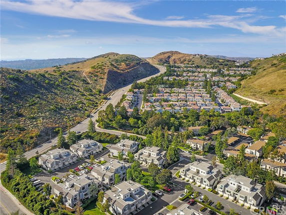 Panoramic view of a residential area with multiple buildings and surrounding hills.