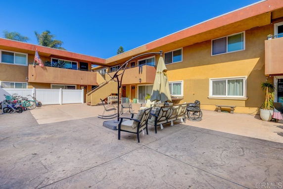 Front view of a two-story apartment building with outdoor seating and stairs.